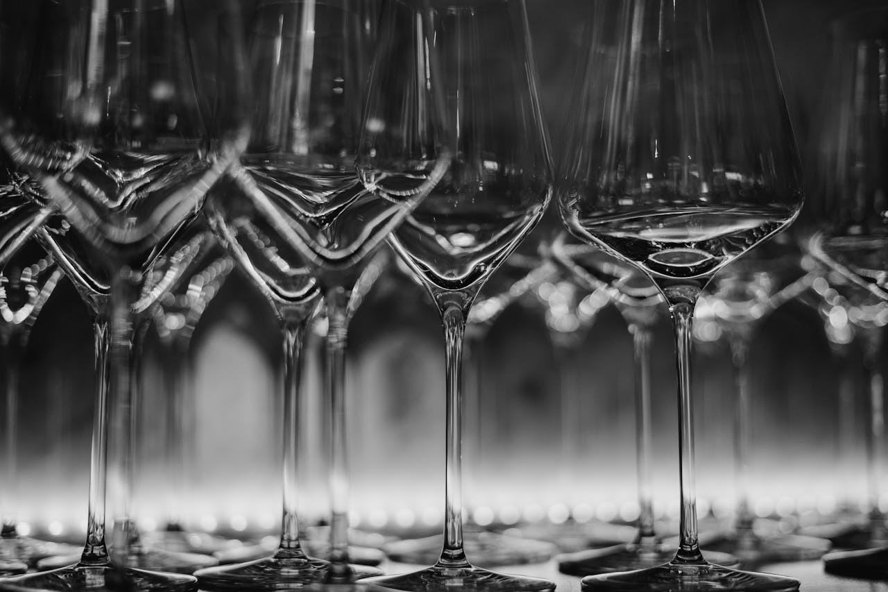 Black and white still life photograph of crystal wine glasses artfully arranged.